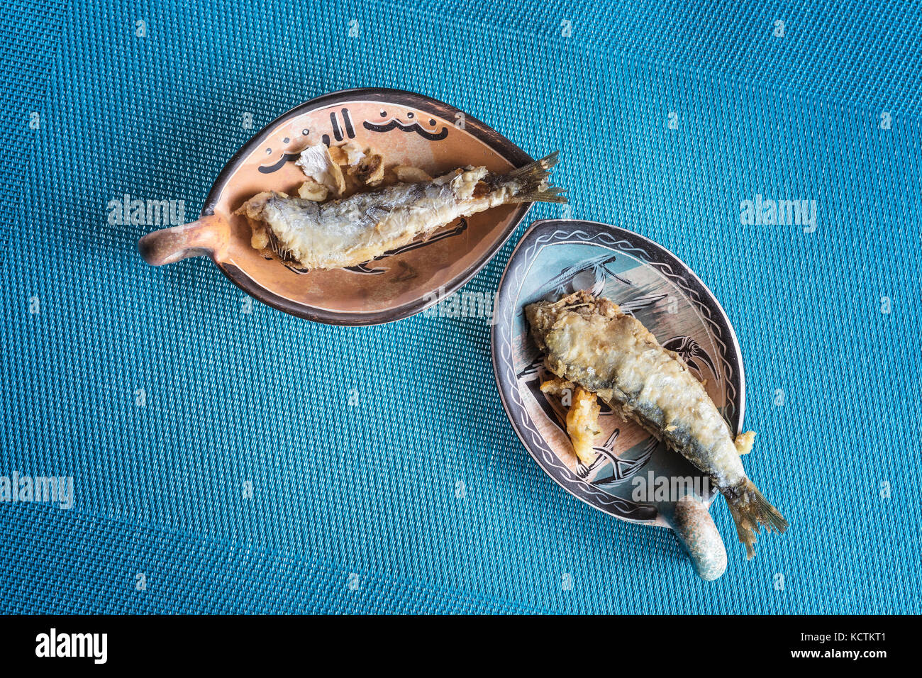 Gebratene Sardinen auf Tellern. Mediterrane Fisch auf blauem Hintergrund Stockfoto