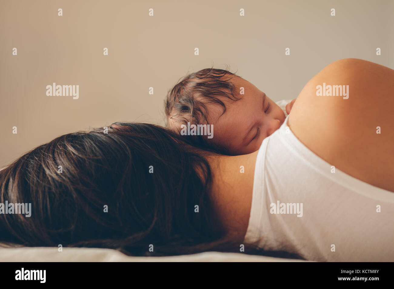 Süßer kleiner Junge mit seiner Mutter zu Hause schlafen. Mutter und Sohn zusammen schlafen im Bett. Stockfoto