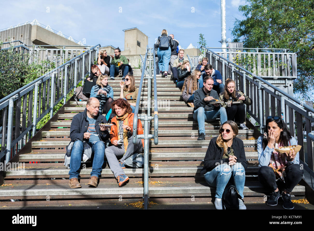 Die Menschen essen auf der Schritte außerhalb der Royal Festival Hall, South Bank Centre, London, SE1, UK Stockfoto