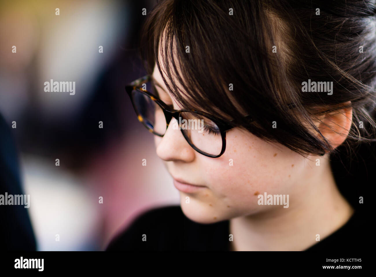 Eine schöne, junge Mädchen mit Brille auf etwas im Interesse suchen. Stockfoto