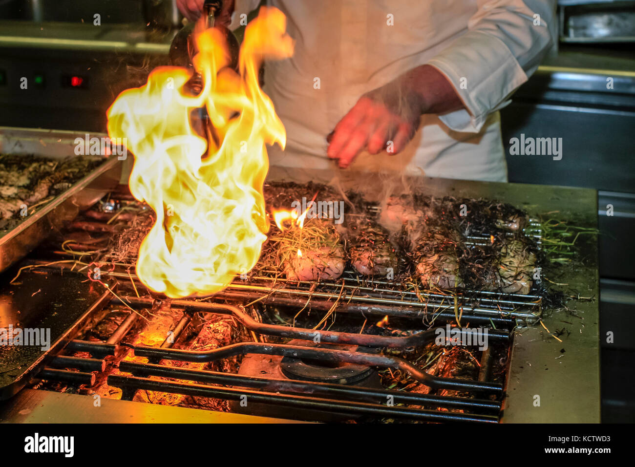 Starkoch Sebastian Frank vom Horvarth in Berlin bereitet beim Rheingau Gourmet Festival in Hattenheim, Eltville am Rhein, Störe im Heumantel zu Stockfoto