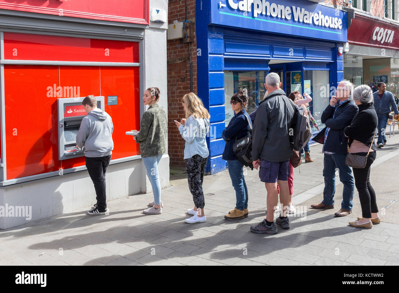 Warteschlange bei cashpoint in Street, Abergavenny, Wales, Großbritannien Stockfoto