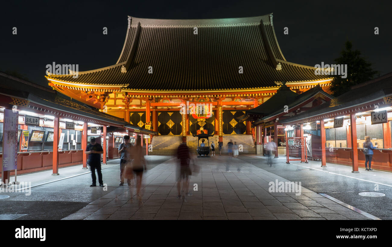 Querformat der Sensoji-tempel mit Leuchten shop Stände, unscharfe Menschen einkaufen und Anzeigen der Tempel. Tempel dominiert Hintergrund Verankerung Szene. Stockfoto