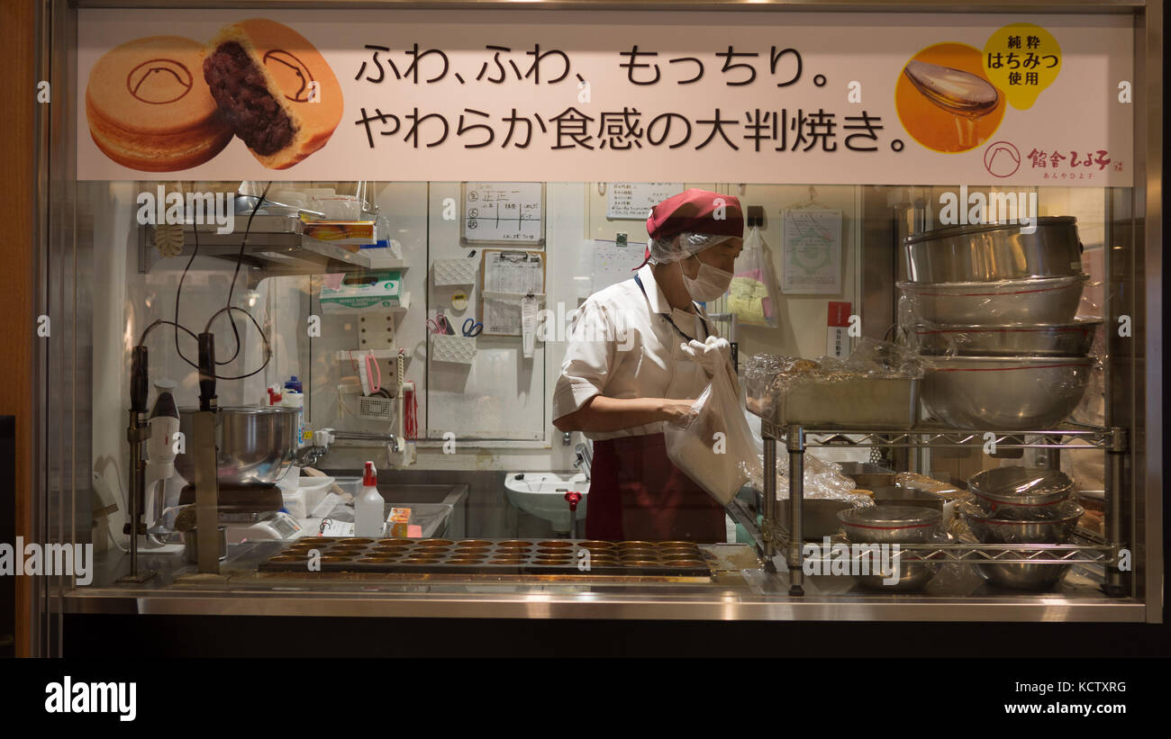 Japanische Bäcker, rote Bohne Kuchen schoss durch Fenster Formen zeigen, Metall Schalen und Beschilderung mit Bildern von Rote-bohnen-Kuchen. Stockfoto