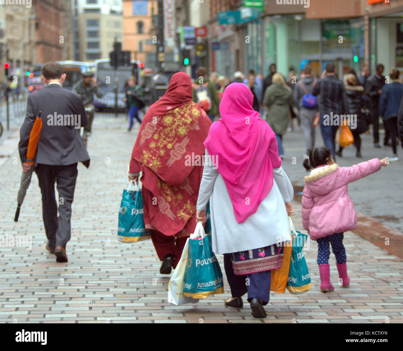 Pakistanische asiatischen hijab Schal Frau Frauen mit Kind, die Familie Einkaufstaschen auf Argyle Street Glasgow Großbritannien von hinten gesehen Stockfoto