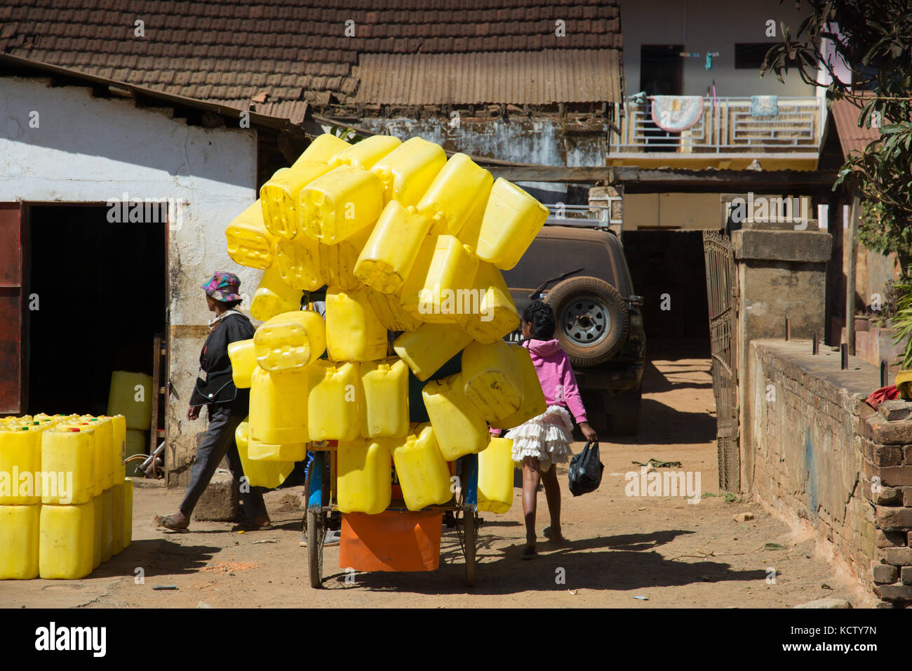 Rikscha mit leuchtend gelben Kunststoff Fässer, Antsirabe geladen, Madagaskar Stockfoto