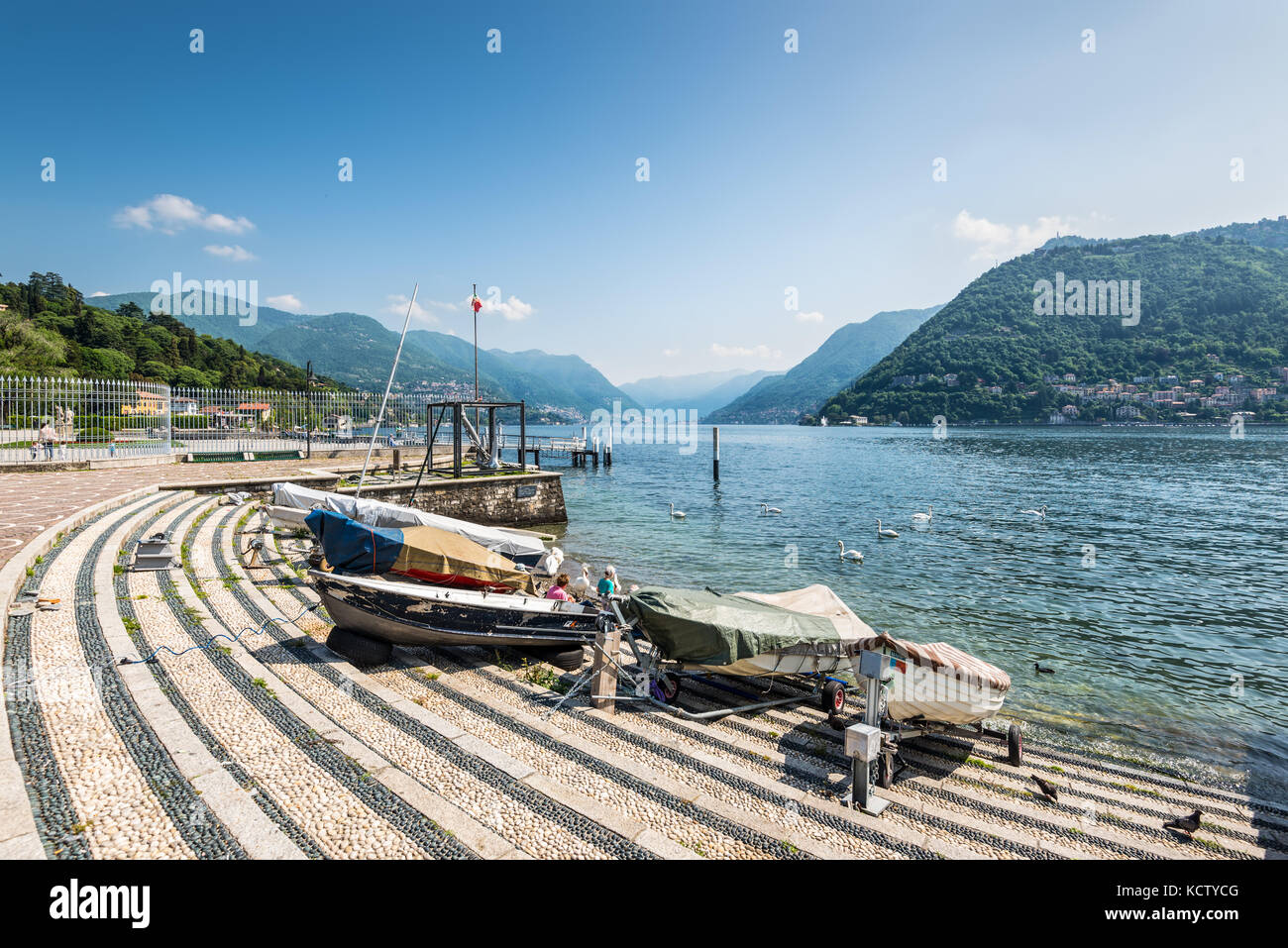 Como, Italien - 27. Mai 2016: Boote am Ufer des Comer Sees, Stadt Como, Italien. Schwäne auf dem See. Stockfoto