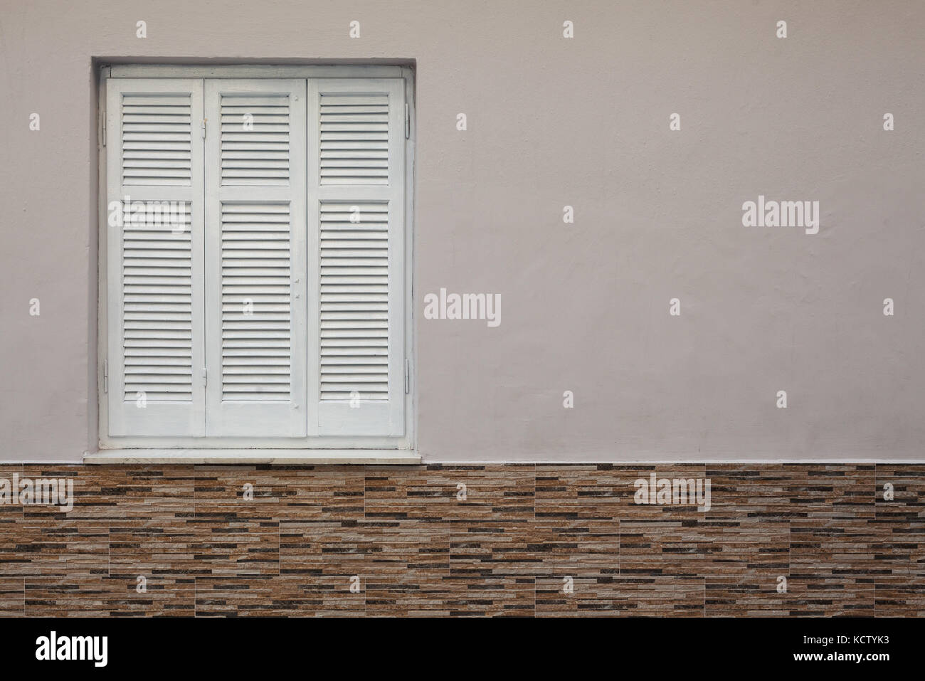 Weiß geschlossene Fenster in der Hauswand, Details der Wand Dekoration und alten Stil Jalousien. Stockfoto