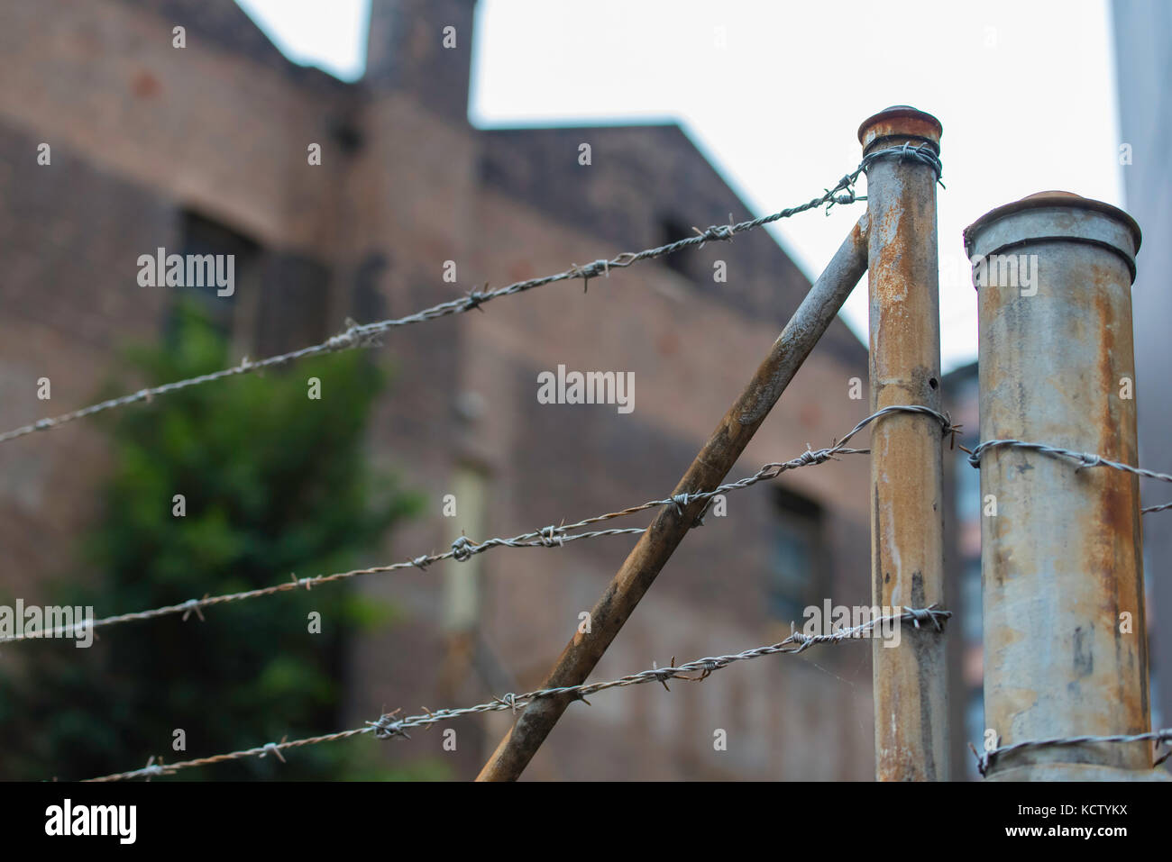 Einen verrosteten Stacheldrahtzaun sichert noch eine verlassene Fabrik in Sydney, Australien Stockfoto