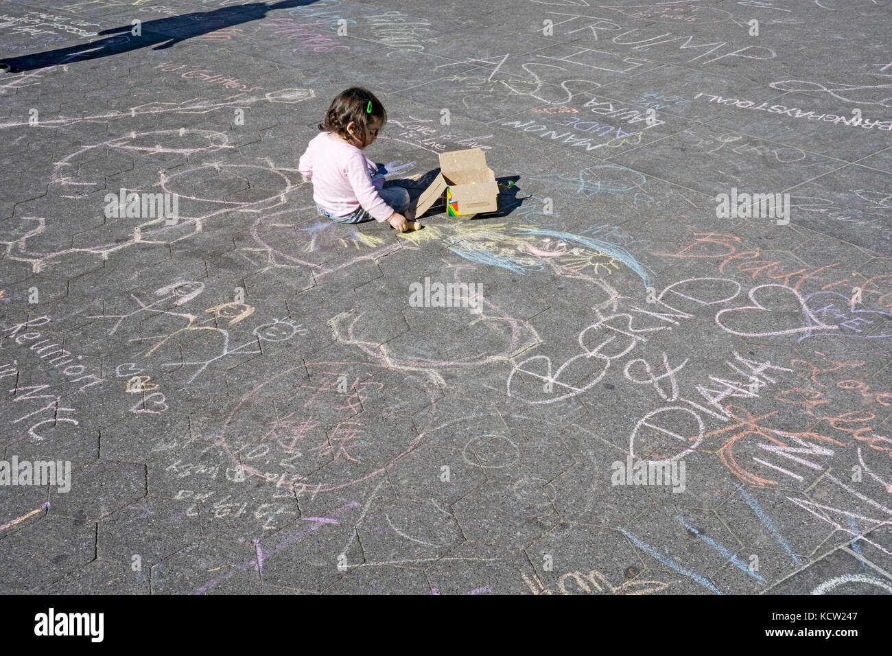 Ein junges Mädchen Zeichnen mit Kreide auf den Boden im Washington Square Park in Greenwich Village, New York City. Stockfoto