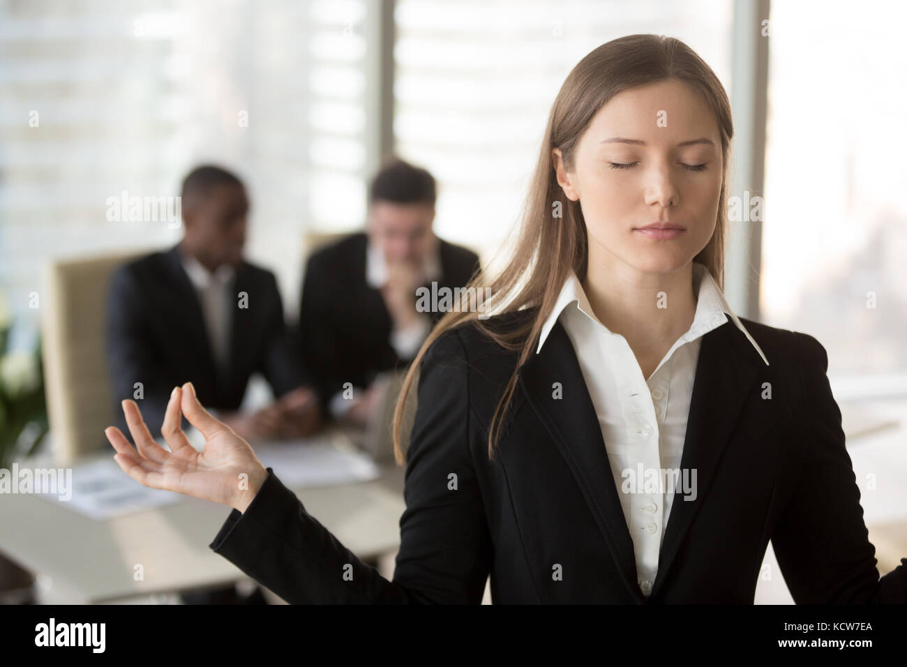 Portrait von attraktiven weiblichen Büroangestellter versucht, in einer schwierigen Situation bei der Arbeit ruhig zu halten. geschäftsfrau Meditieren mit geschlossenen Augen, ohne Pr Stockfoto