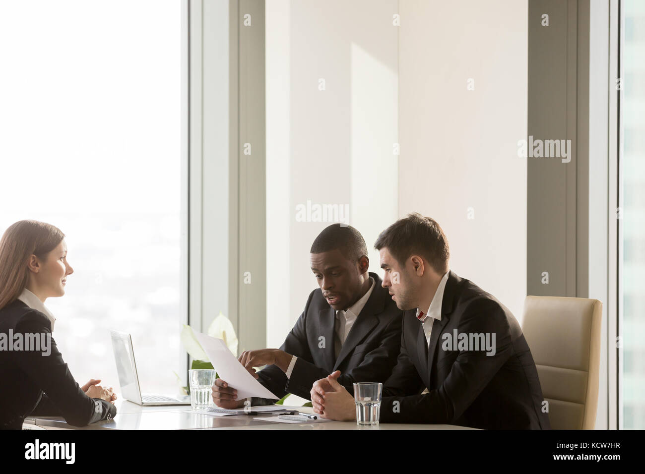 Afrikanische amerikanische Arbeitgeber Kandidaten diskutieren Lebenslauf mit kaukasischen Kollegen, Lesen und verweist auf wichtige cv Informationen. nervösen Jungen Weiblich Stockfoto