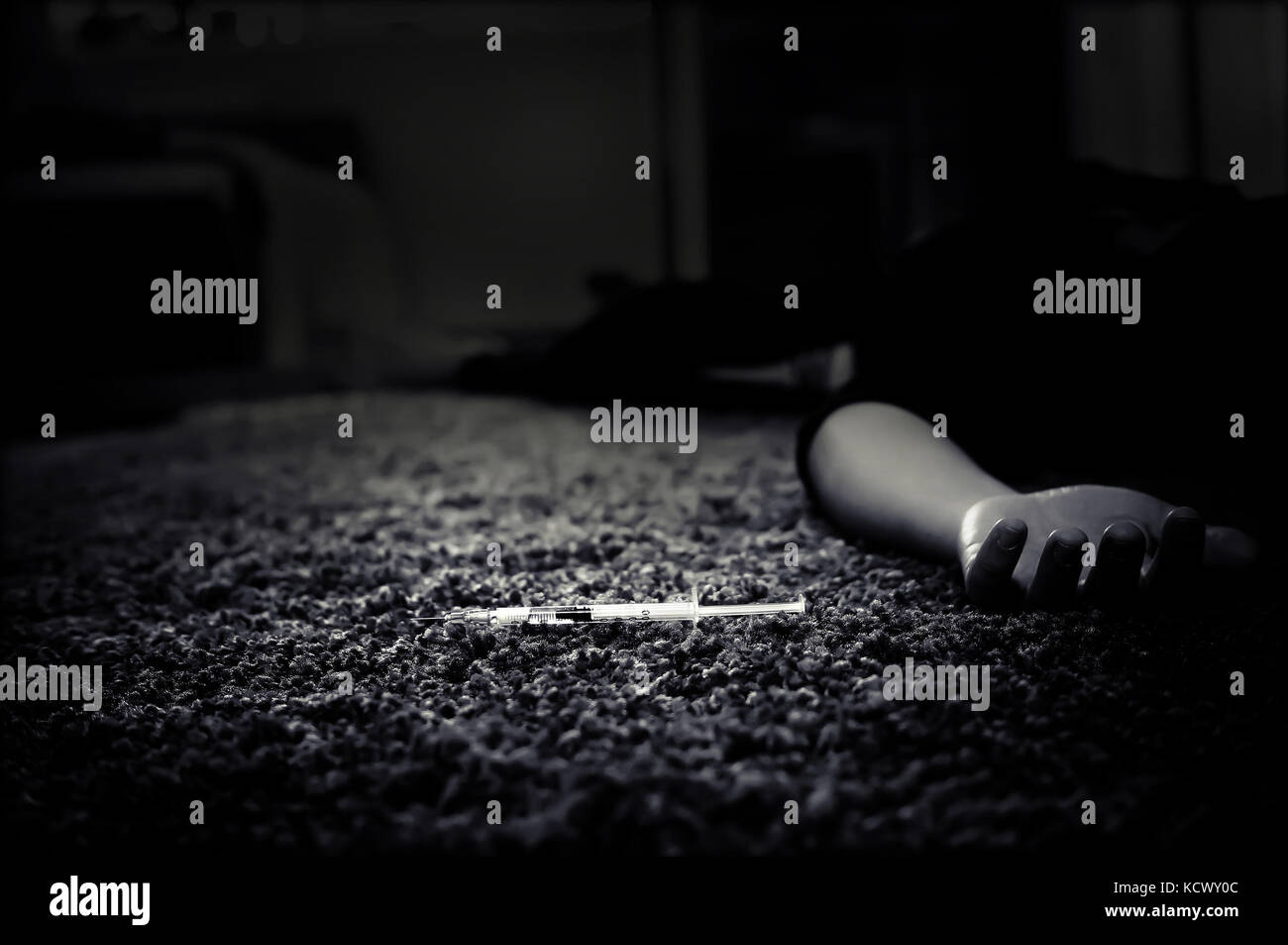 Schwarz-weiß Foto von Hand ein Drogenabhängiger und eine Spritze mit Heroin auf dem Boden liegt. anti Droge Konzept. männlicher Drogenabhängiger Hand, Drogen, Betäubungsmittel Stockfoto
