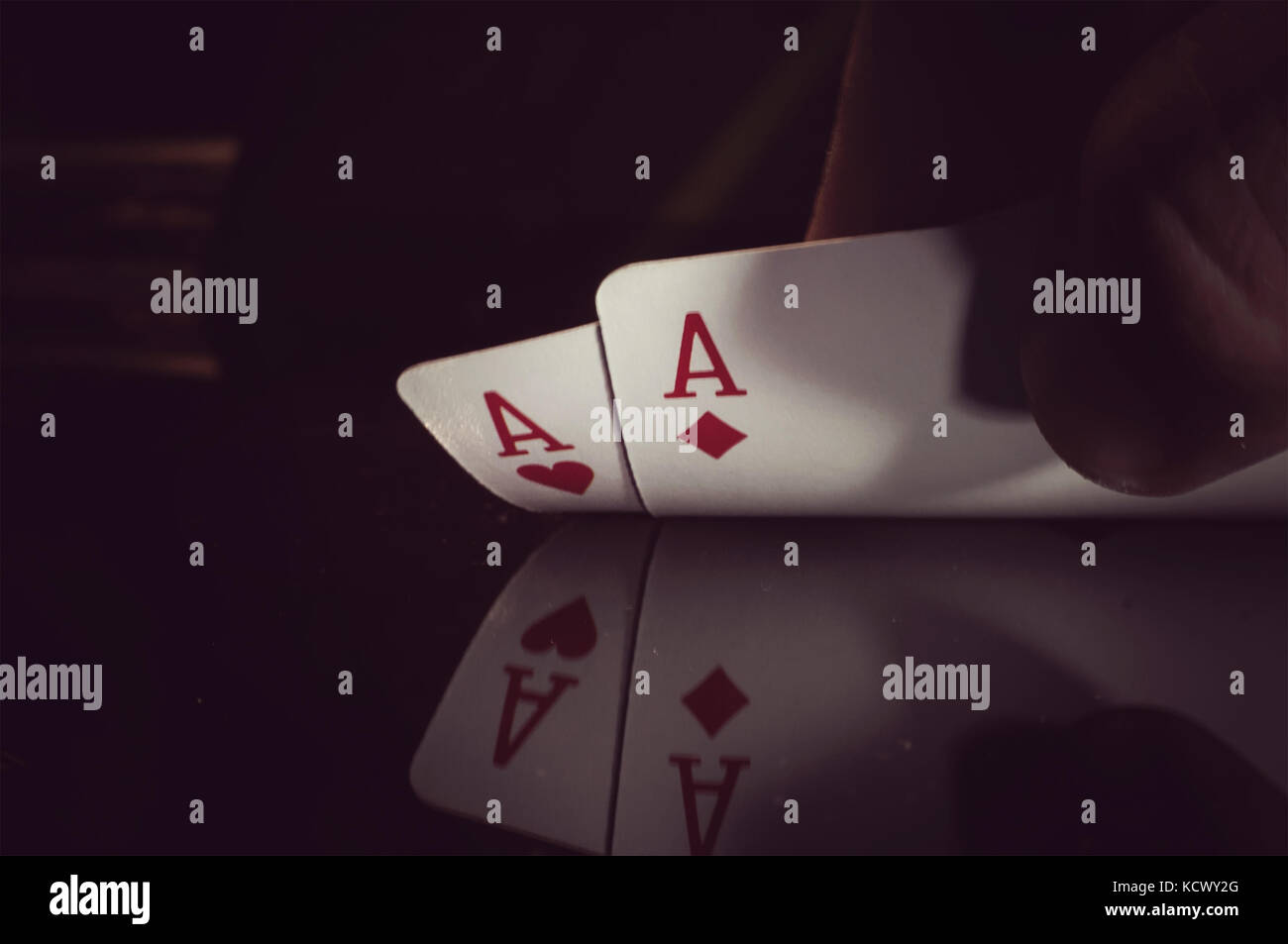 Die menschliche Hand, die zwei Asse auf schwarzem Hintergrund Stockfoto