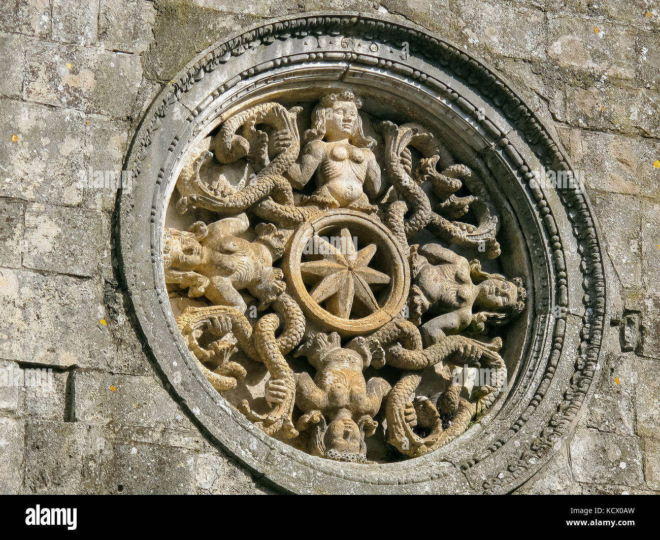 Italien Apulien Monte Sant'Angelo (FG): Rose des Portals der Kirche von San Pietro mit vier Sirenen bicaudate und mit codierten Non-woven-Beine. Stockfoto