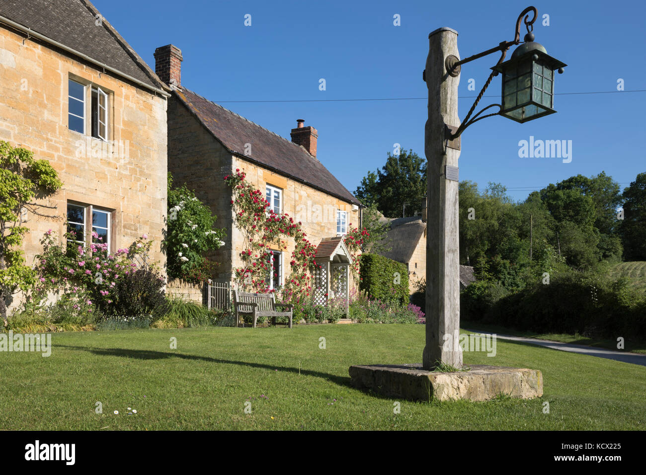 Village Green mit Alte Laterne und Cotswold Stone Cottages mit Rosen, Stanton, Cotswolds, Gloucestershire, England, Vereinigtes Königreich, Europa abgedeckt Stockfoto