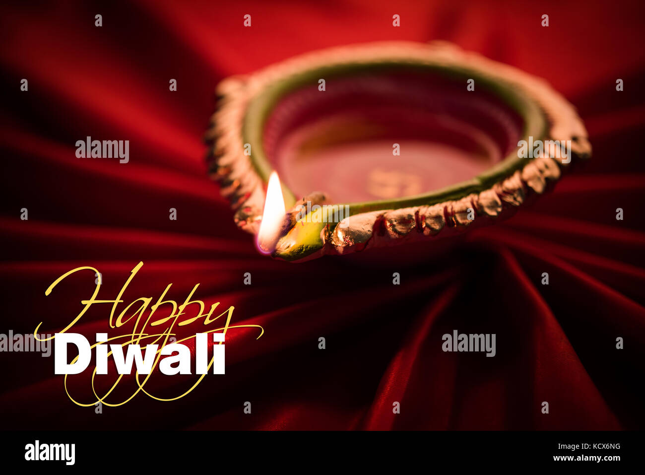 Happy diwali Grußkarte - große beleuchtete Diwali diya oder Ton Lampe über satin Tuch erstellen strahlen Effekt in Tuch, stimmungsvolle Beleuchtung, selektive Stockfoto