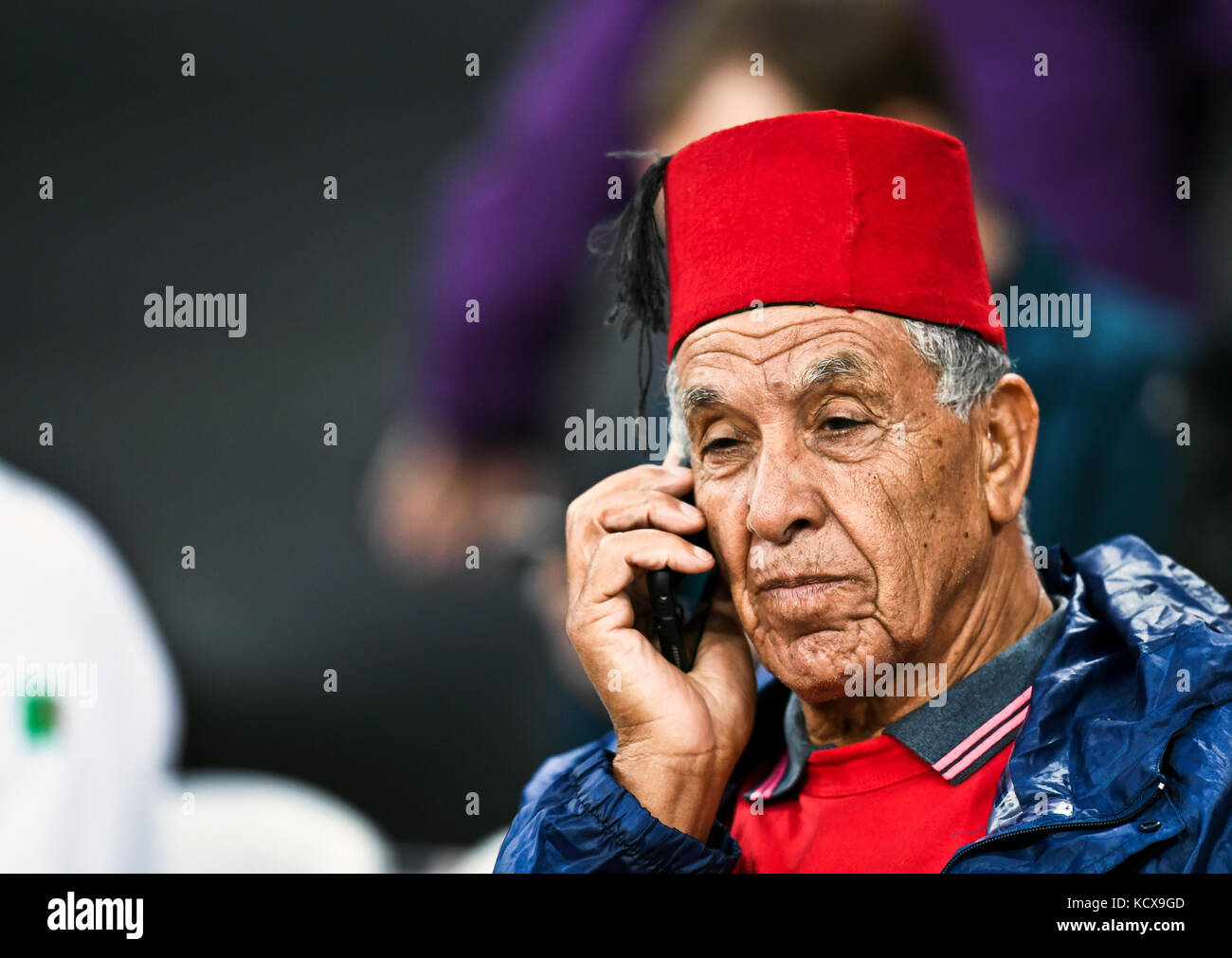 Marokkanischen Mann mit einem Fes, beim Bezahlen im Restaurant anstellen auf dem Mobiltelefon Stockfoto