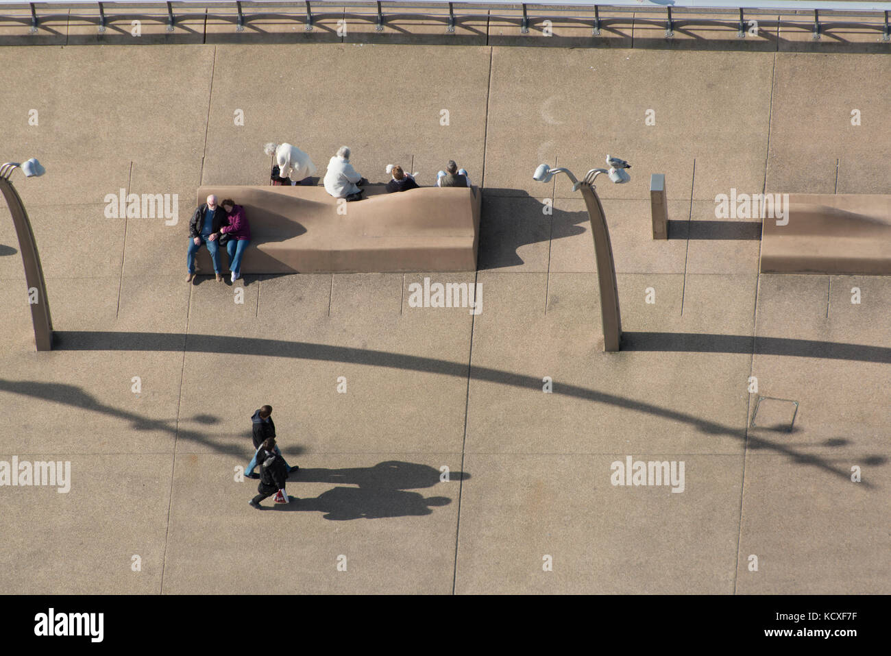 Straßenszene von Blackpool am Meer. Paare gehen und ruhen sich auf einer Bank aus. Lee Ramsden / Alamy Stockfoto