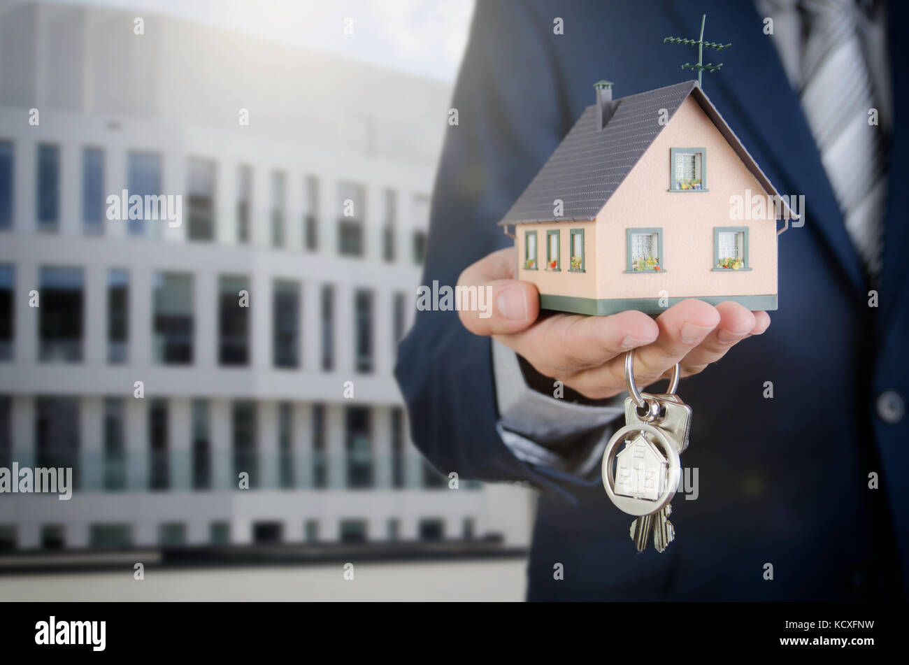 Real estate agent mit home Schlüssel und Haus Miniatur. Untertyp der Schlüssel apartment Immobilien Home Haus Hausbesitzer Konzept Stockfoto