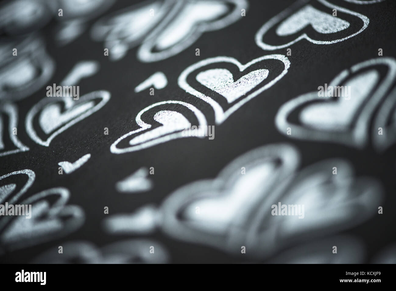 Makro von Silber Herzen auf einem schwarzen Hintergrund grau Stockfoto