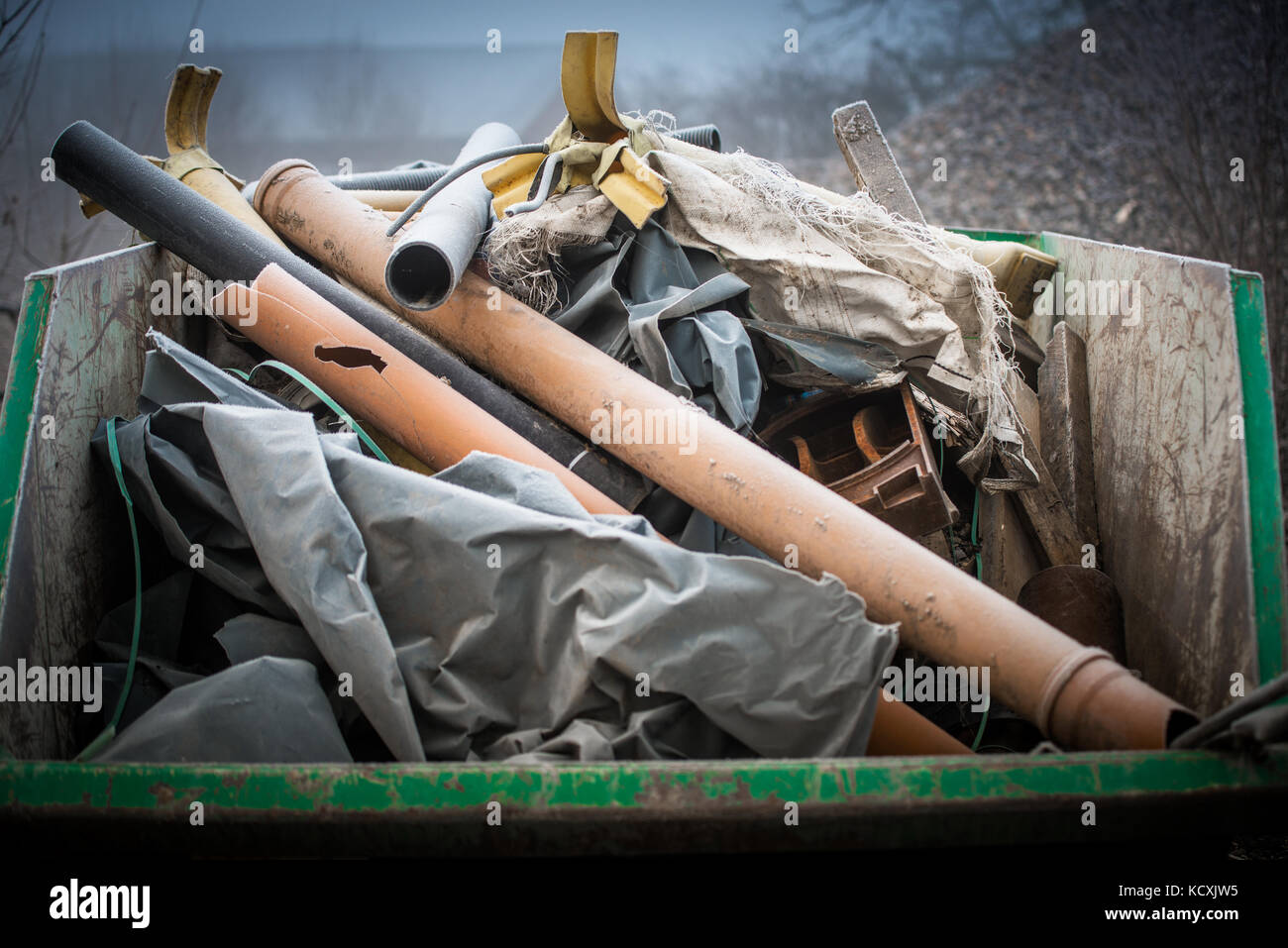 Waster container bin mit Müll auf einer Baustelle im Winter Stockfoto