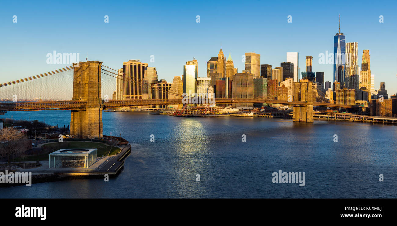 Sonnenaufgang auf der Brooklyn Bridge, die den East River und die Wolkenkratzer von Manhattan (Panoramablick). New York City Stockfoto