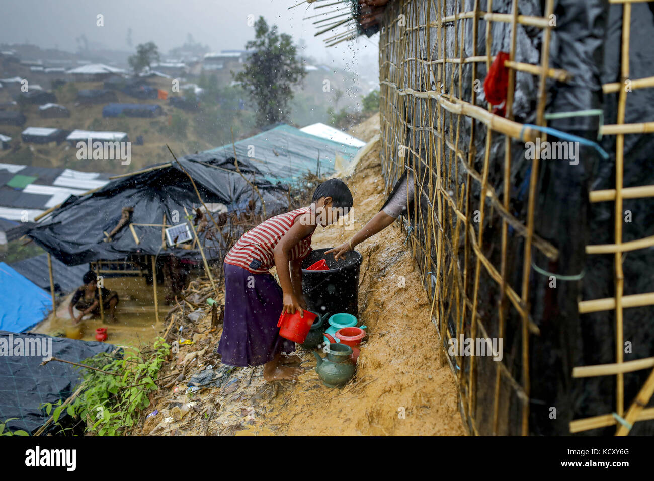 Ukhiya, Bangladesch. Oktober 2017. Rohingya Flüchtlingskind sammelt Wasser aus Regen, der aus dem Staat Myanmar Rakhine auf Ukhiya, Cox's Basar, kommt. Nach Angaben des UNHCR sind im letzten Monat mehr als 500.000 Rohingya-Flüchtlinge vor der Gewalt in Myanmar geflohen, die meisten versuchten, die Grenze zu überqueren und Bangladesch zu erreichen. Kyaw Tint Swe, der Minister für das Amt des Staatsrats Myanmars, besuchte Bangladesch und stimmte zu, die Rohingyas nach gegenseitigem Einvernehmen mit der Regierung Bangladeschs zurückzuholen. Quelle: K M Asad/ZUMA Wire/Alamy Live News Stockfoto