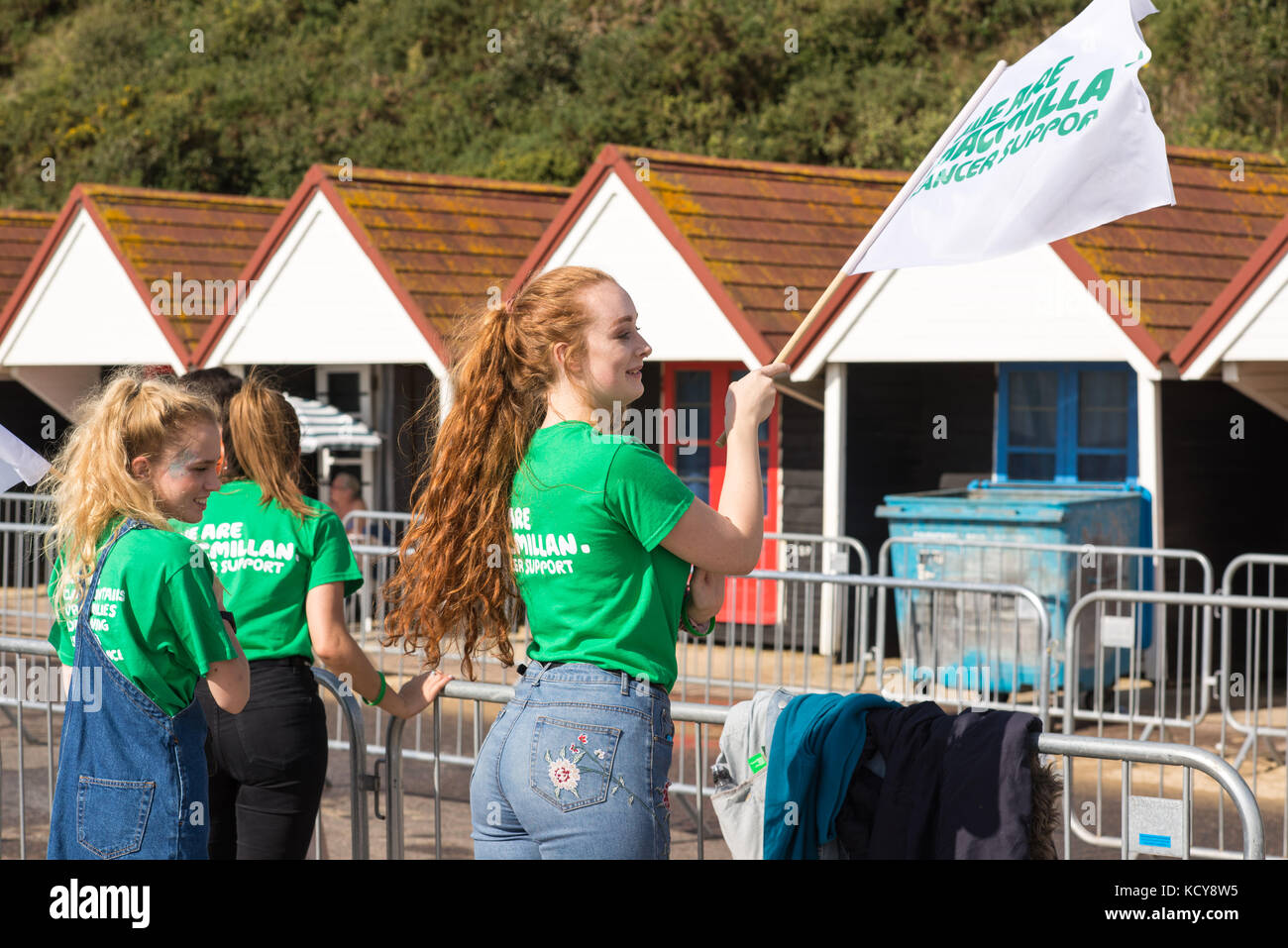Bournemouth, Dorset, Großbritannien, 8.. Oktober 2017. Macmillan-Wohltätigkeitsarbeiter winken Flagge und unterstützen Läufer beim Bournemouth Marathon Festival. Stockfoto