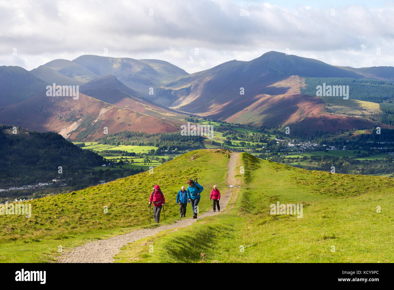 Gruppe von Wanderern klettern Latrigg mit Bergen im Hintergrund, in der Nähe von Keswick, Cumbria, England, Großbritannien Stockfoto