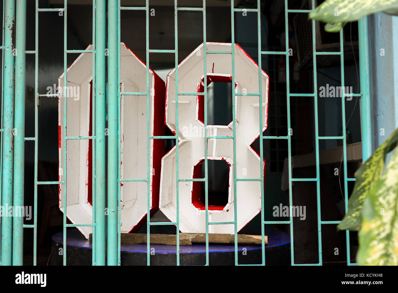 Numbers '08 'Null Acht dreidimensionale Zeichen hinter einem Shop Frontgitter. Stockfoto