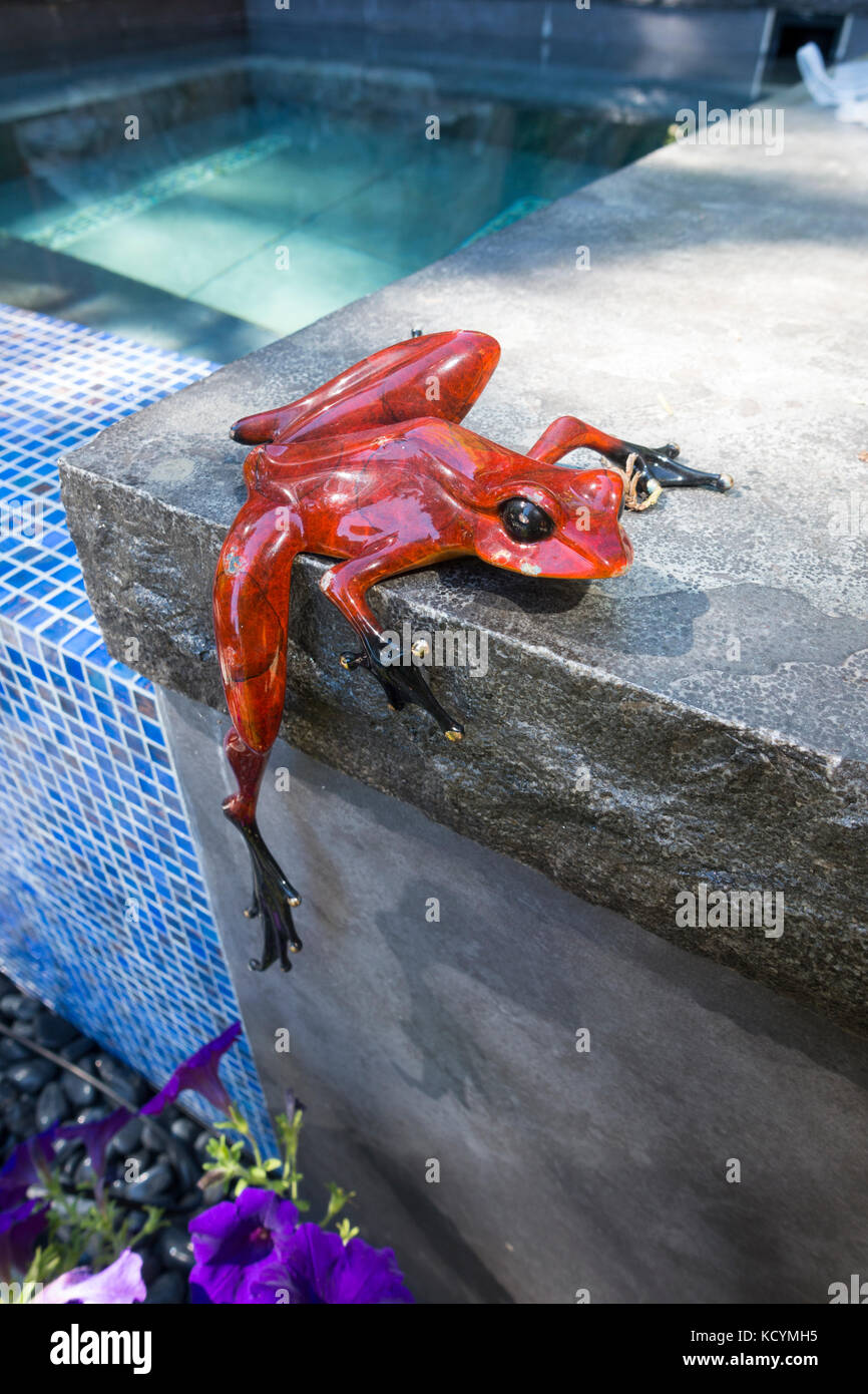 Nahaufnahme eines dekorative Frosch an der Seite eines Garten Whirlpool festhalten. und Pool. Stockfoto