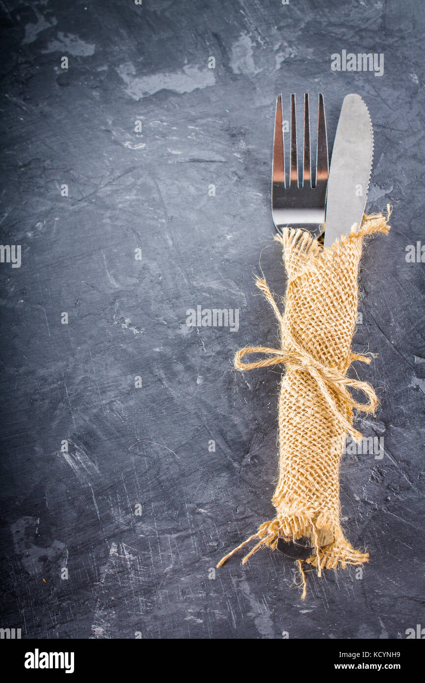 Gabel mit einem Messer in die Entlassung auf grauem Hintergrund. Stockfoto