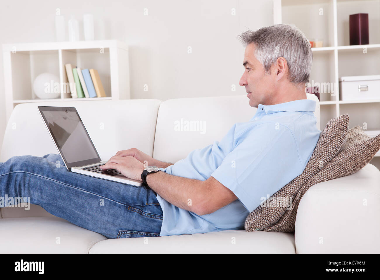 Portrait von Happy Reife mit Laptop auf der Couch Mann Stockfoto