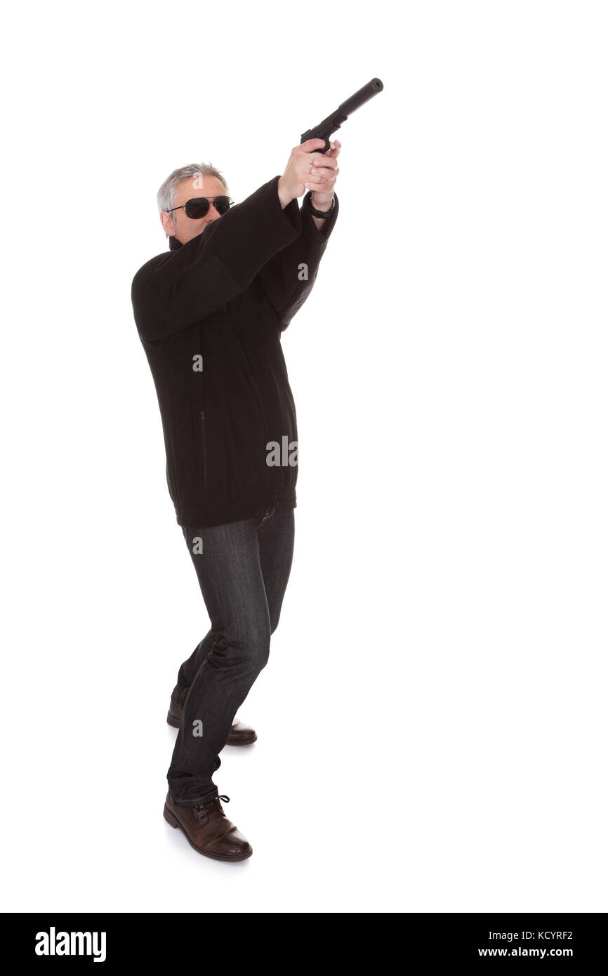 Reifer Mann mit weißem Hintergrund mit Pistole Stockfoto
