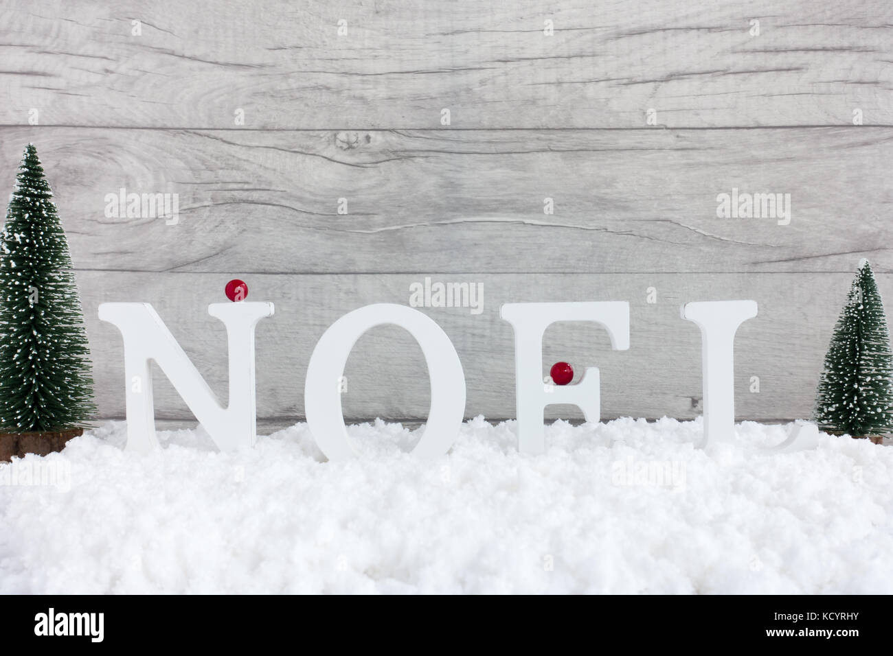 Winter Szene mit Weihnachtsbäumen und Noel in Holz- Buchstaben in Schnee und grau Holz- Hintergrund steht geschrieben. Stockfoto