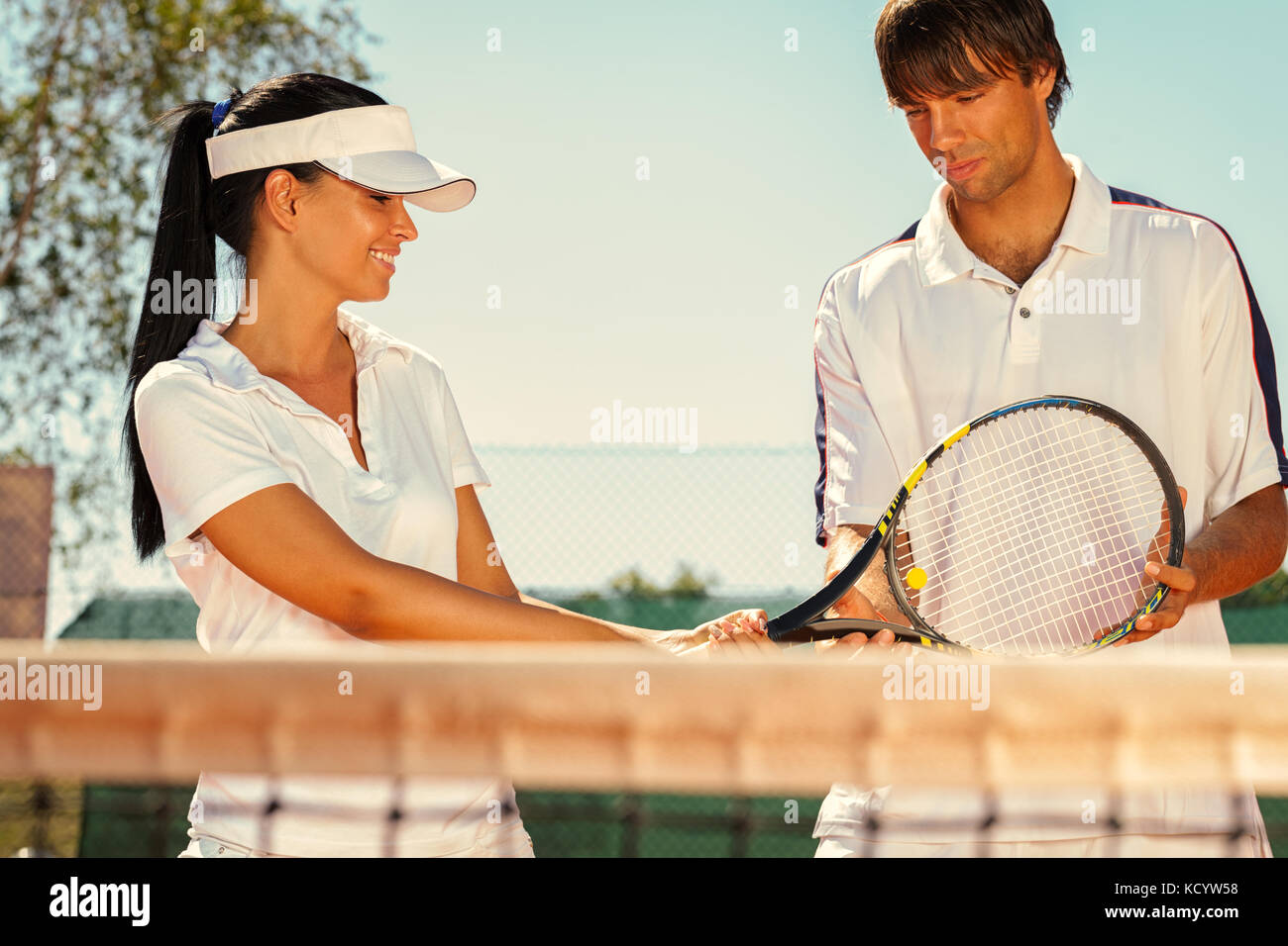 Junges Paar der Tennisspieler sprechen Stockfoto