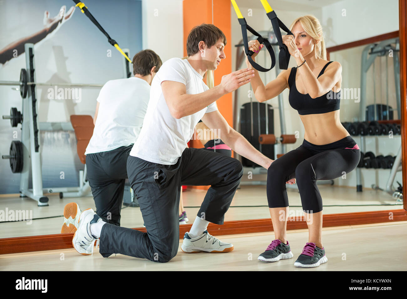 Frau tun Workout mit Fitness Spanngurte unter Aufsicht ein Personal Trainer Stockfoto