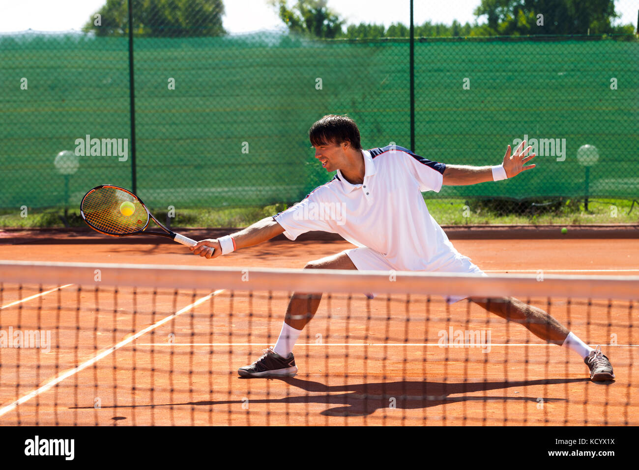 Hübscher junger Mann Tennis spielen Stockfoto