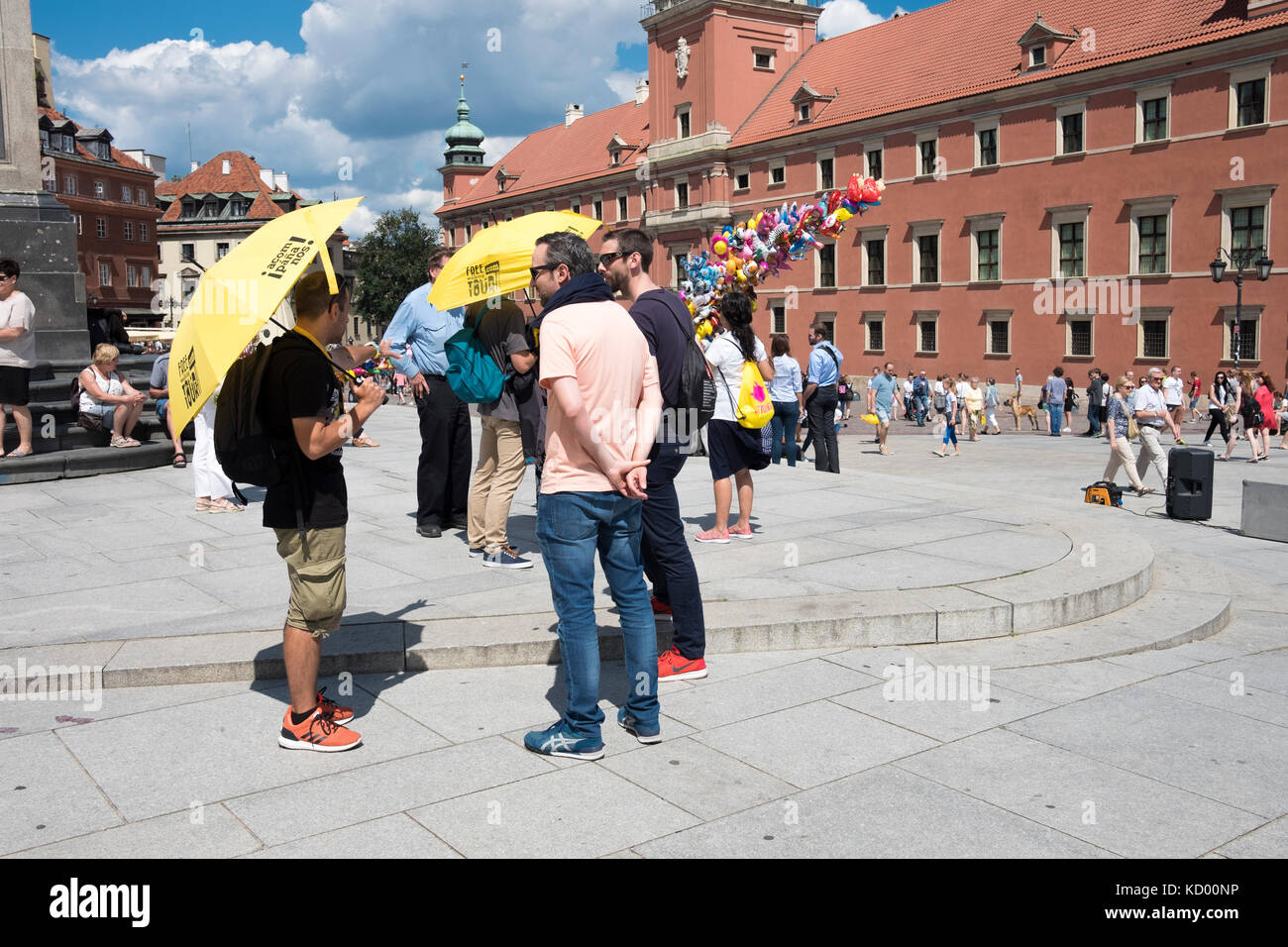 Tour Guides mit gelben Sonnenschirmen vor dem Königlichen Schloss, Plac Zamkowy, die Warschauer Altstadt, Polen. Stockfoto