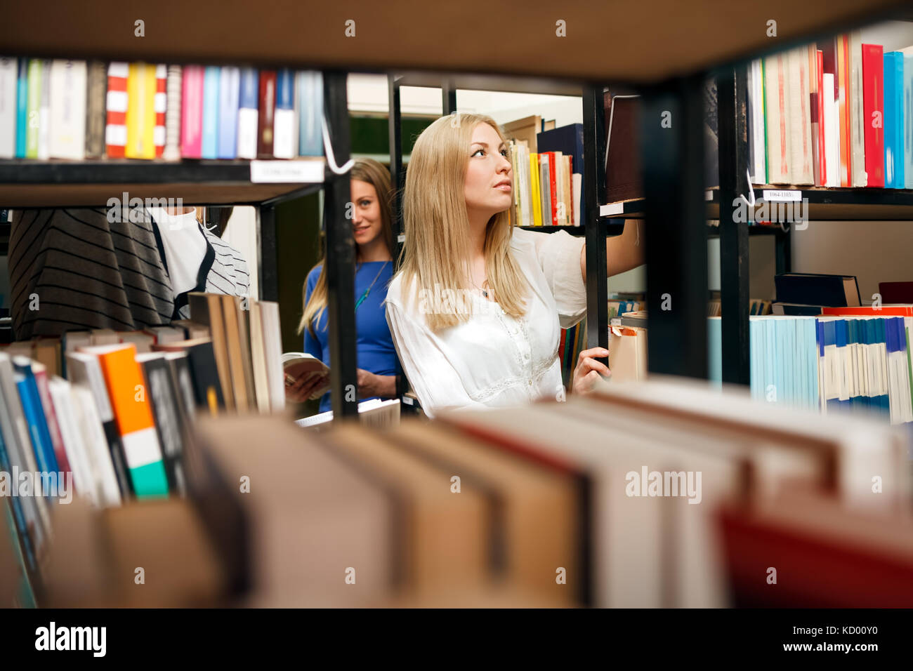 Schüler wählen Bücher in der Universitätsbibliothek Stockfoto