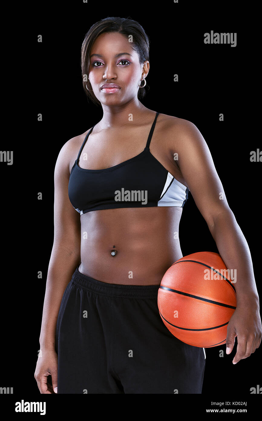 Attraktive sportliche afro Frau mit Basketball über Schwarz posiert Stockfoto