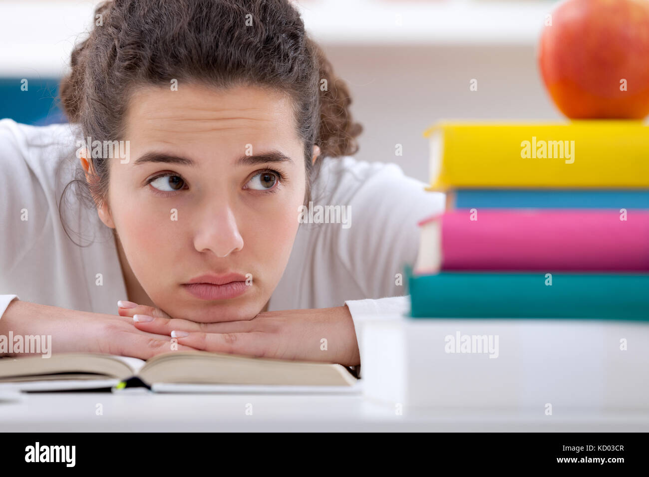 Traurig Schulmädchen mit Lernschwierigkeiten, an Bücher suchen Stockfoto
