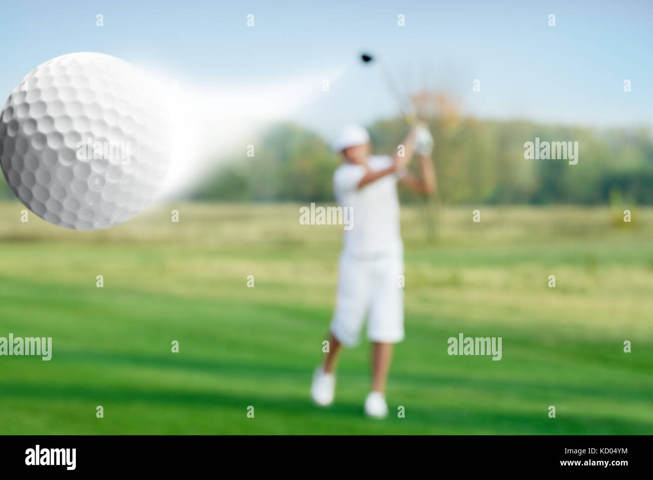 Golfspieler schlagen einer fliegenden Kugel Stockfoto