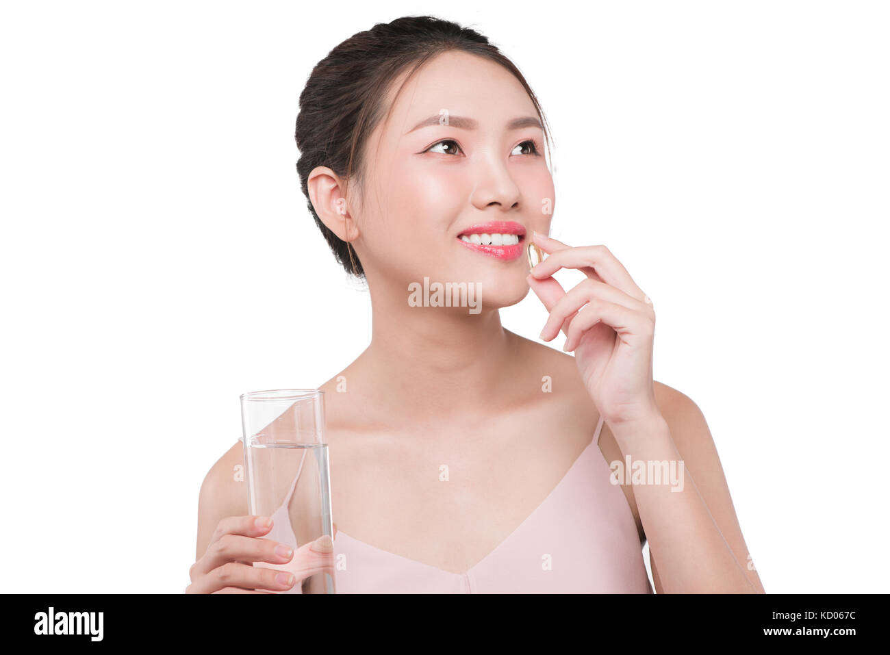 Lächelnd asiatische Frau essen Pillen und Trinkwasser Stockfoto