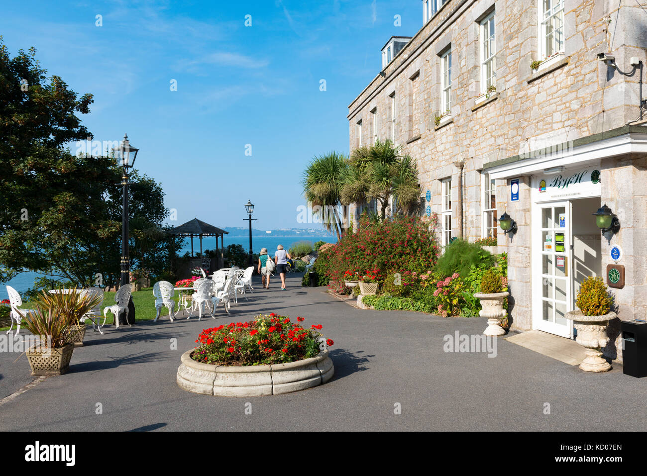 Haupteingang des Berry Head Hotel, Brixham Torbay, Devon. Blick in die Bucht und mit zwei Personen auf der Terrasse in der Ferne. Sommer Stockfoto