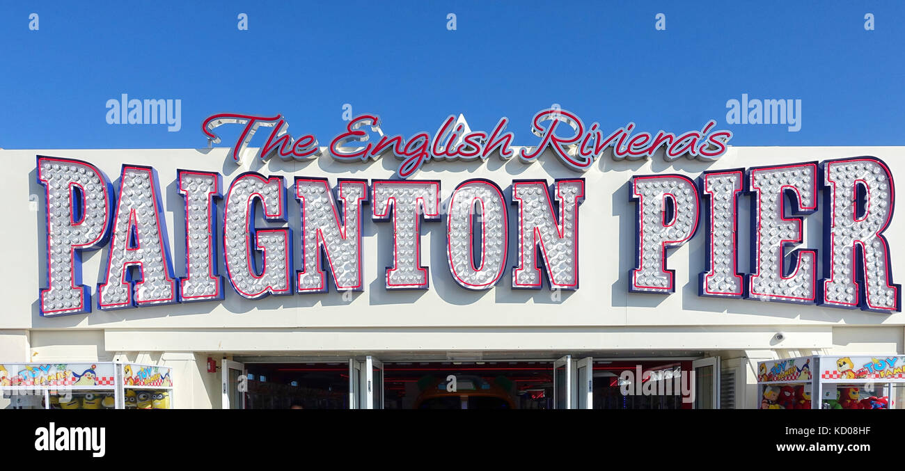 Die Leuchtreklame über dem Eingang Paignton Pier-rosa-umrandete Zeichen gegen eine vibrant blue sky. Stockfoto