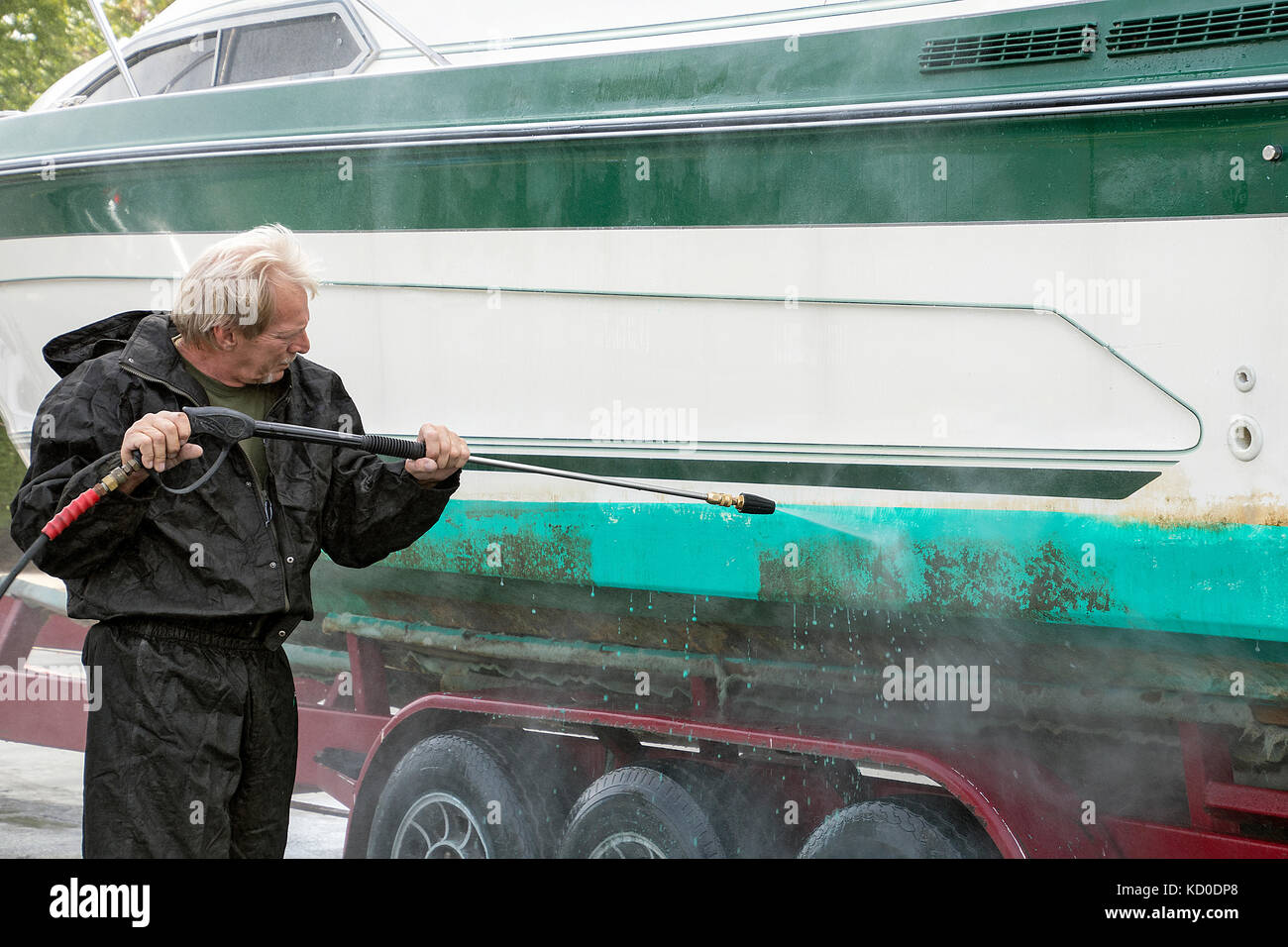 Kaukasische Mann macht Waschen schmutzige Bootsrumpf Stockfoto