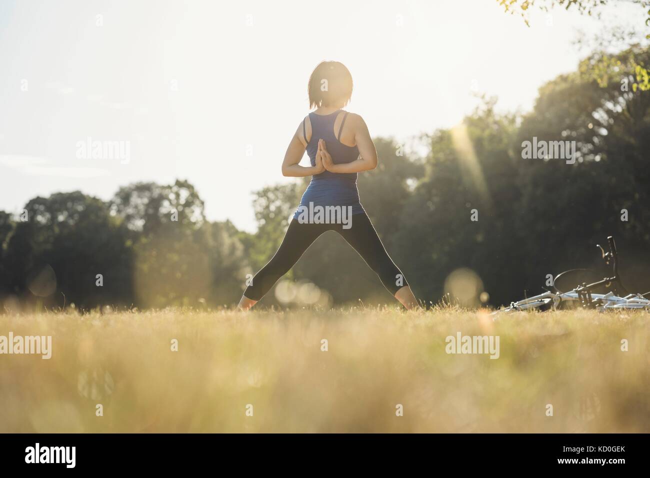 Reife Frau im Park, In Yoga Positionen, die Hände hinter dem Rücken, Rückansicht Stockfoto