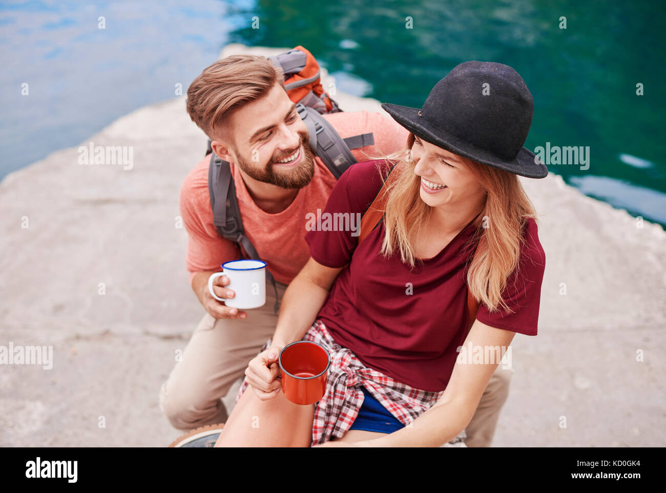 Paar, das durch Wasser holding Emaille Becher lächelnd, Krakow, Malopolskie, Polen, Europa Stockfoto